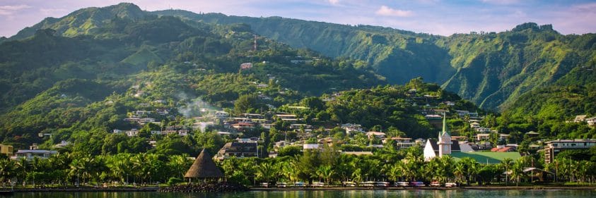 Landscape of Tahiti with mountains and village close to the port of Papeete, French Polynesia. Cruise and honeymoon destination.