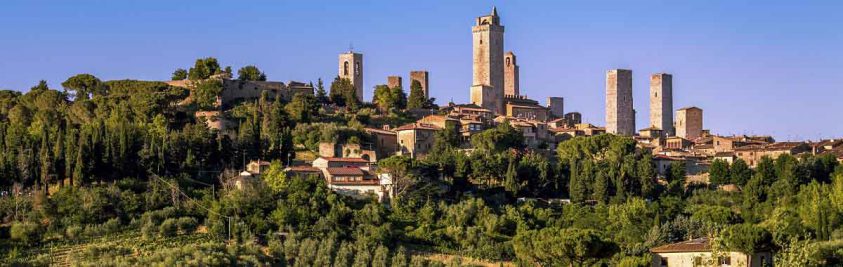 Rolling green hillsides and buildings of Tuscany